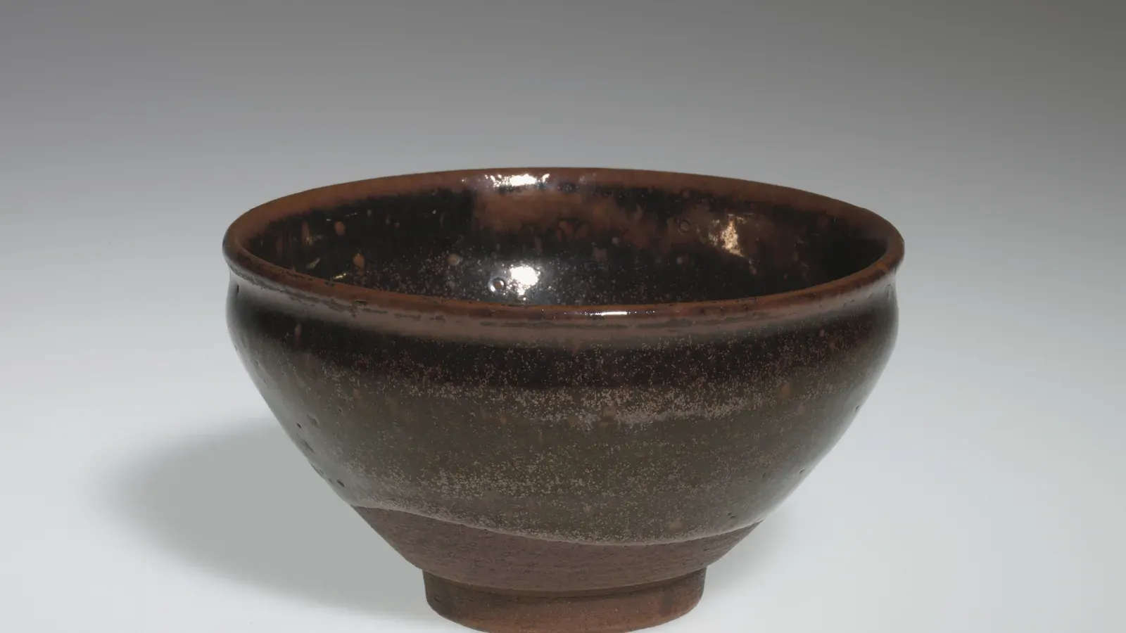 A tenmoku tea bowl glazed a lustrous brown-black