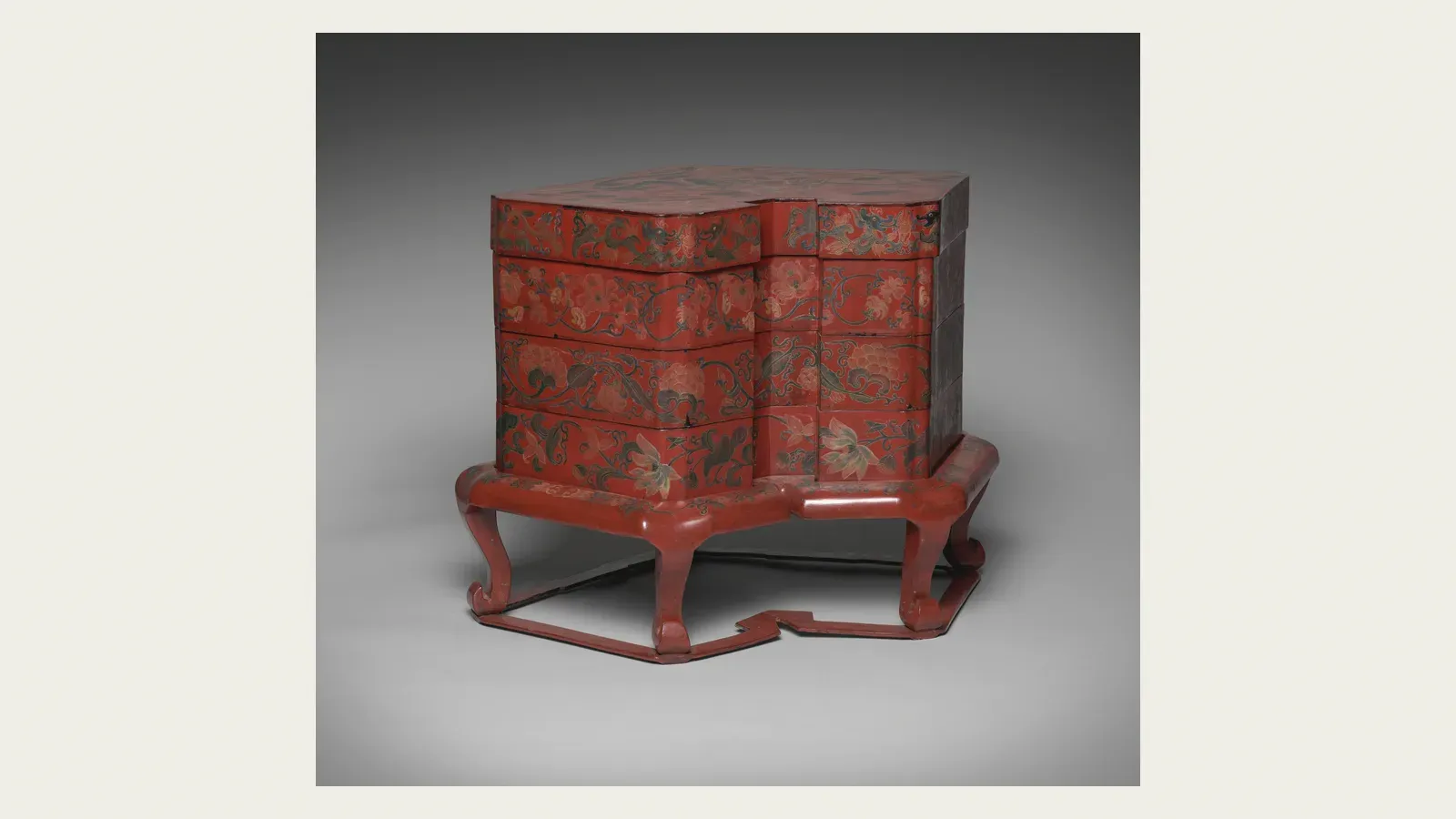 A tiered red lacquer box for kaiseki food, on its stand