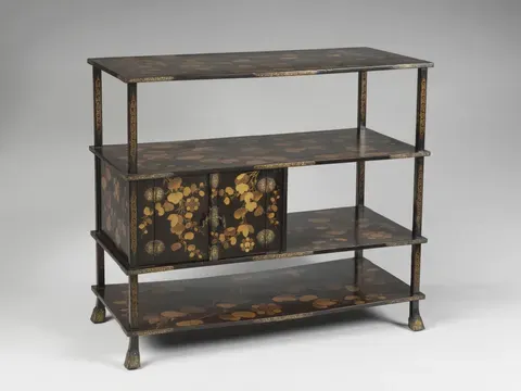 A black-and-gold tiered stand for displaying tea utensils