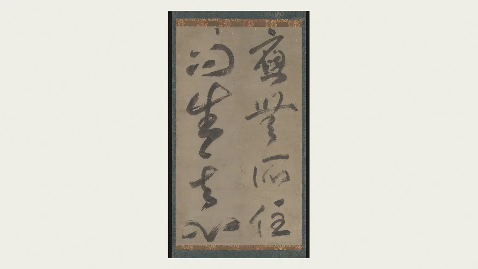 A hanging scroll of bold, flowing cursive ink calligraphy