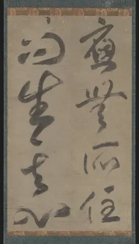 A hanging scroll of bold, flowing cursive ink calligraphy