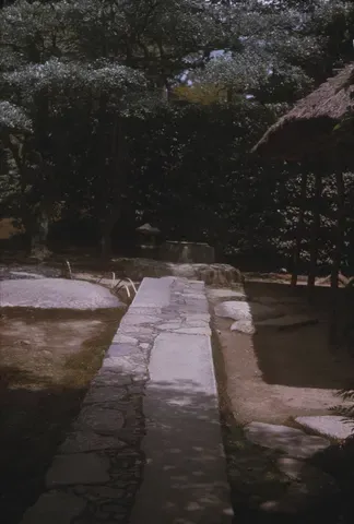A path of stepping stones leading to a stone water basin